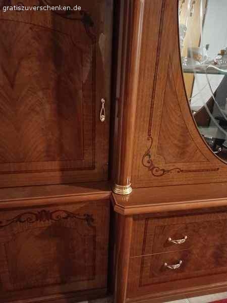 Wohnzimmer Schrank im italienischen Stil. Wohnzimmer Schrank im italienischen Stil. Sehr gut erhalten. Keine Kratzer, keine Fehler Maße: 3m breit 2,21 hoch, wenn der ovale Kranz aufgesetzt wird (derzeit nicht auf dem Bild) Farbe ist rotbraun, Furnier, mit Einlagen. 6 Korpus-Teilen zzgl. Türen, Kranz, Glas- und Holzeinlage-Böden. Geschirr, Kristall-Gläser etc. können wir gerne zum Teil mit verschenken