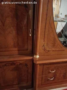 Wohnzimmer Schrank im italienischen Stil. Wohnzimmer Schrank im italienischen Stil. Sehr gut erhalten. Keine Kratzer, keine Fehler Maße: 3m breit 2,21 hoch, wenn der ovale Kranz aufgesetzt wird (derzeit nicht auf dem Bild) Farbe ist rotbraun, Furnier, mit Einlagen. 6 Korpus-Teilen zzgl. Türen, Kranz, Glas- und Holzeinlage-Böden. Geschirr, Kristall-Gläser etc. können wir gerne zum Teil mit verschenken